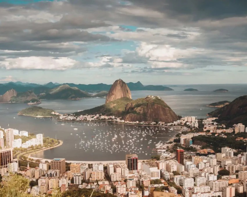 Imagem da vista aérea da cidade do Rio de Janeiro mostra o Pão de Açúcar, mar e prédios em um dia de céu azul para ilustrar matéria sobre os bairros mais populosos do Rio de Janeiro