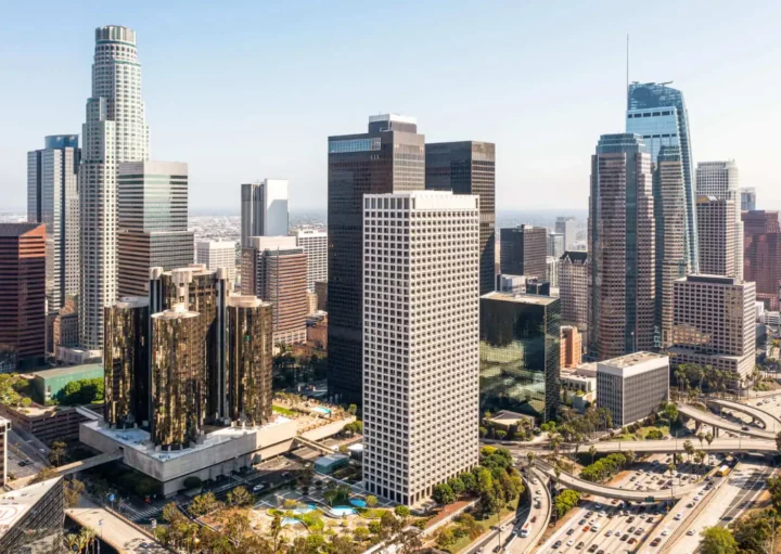 Imagem aérea do centro urbano de uma cidade mostra prédios, avenidas e vegetação para ilustrar matéria sobre as vantagens de morar no centro