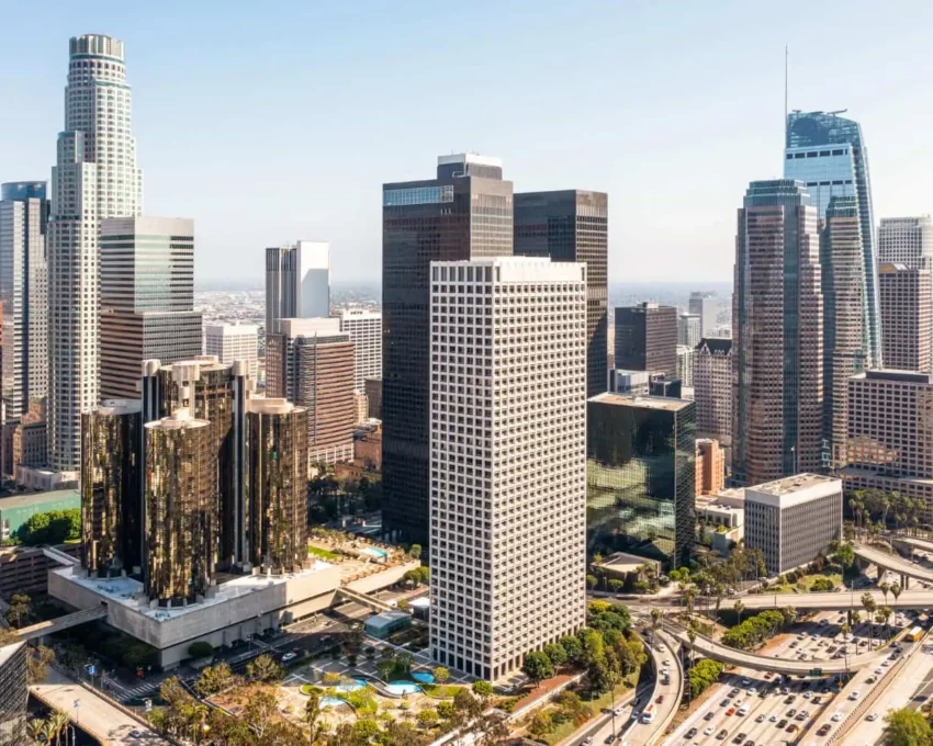 Imagem aérea do centro urbano de uma cidade mostra prédios, avenidas e vegetação para ilustrar matéria sobre as vantagens de morar no centro