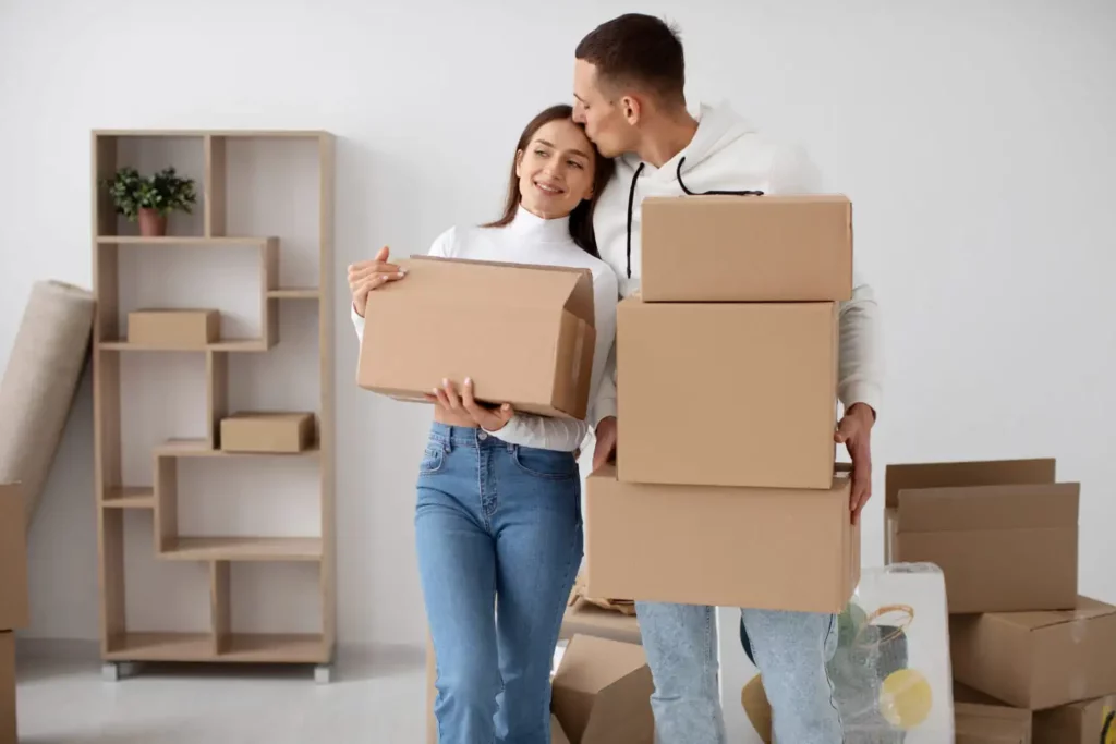 Imagem de um casal formado por um homem e uma mulher segurando algumas caixas de papelão dentro de uma casa para ilustrar matéria sobre o direito de vigência no imóvel alugado